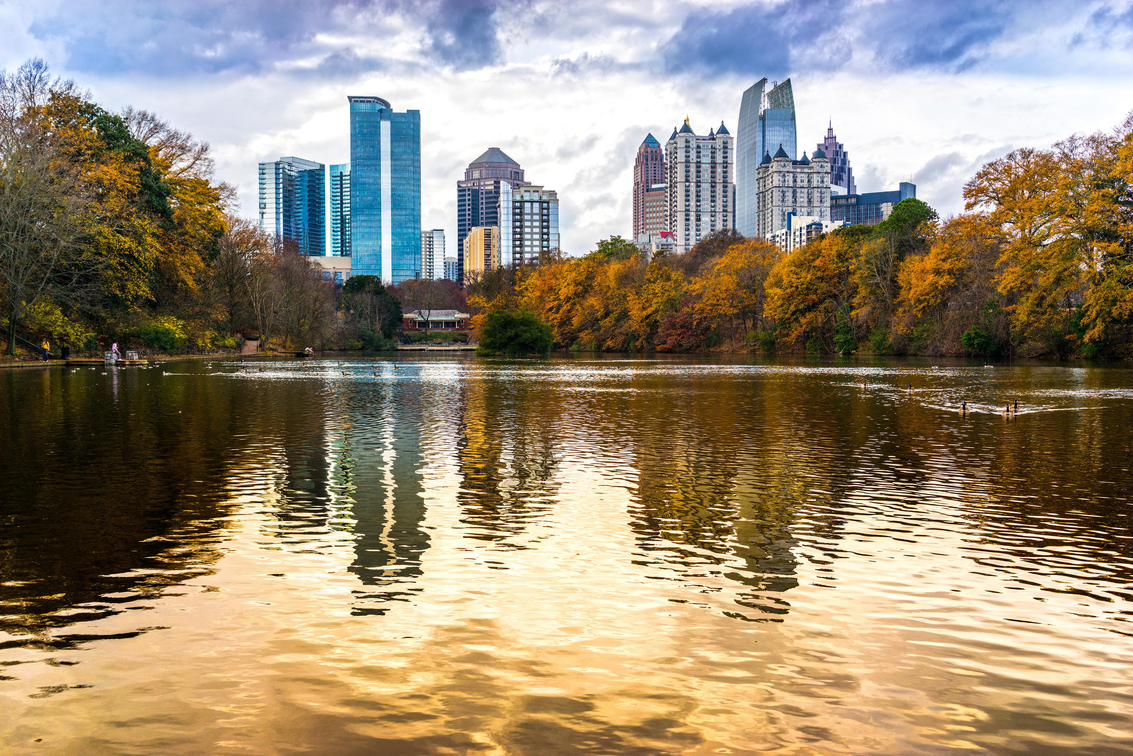 Atlanta, Georgia skyline against a lake with fall trees
