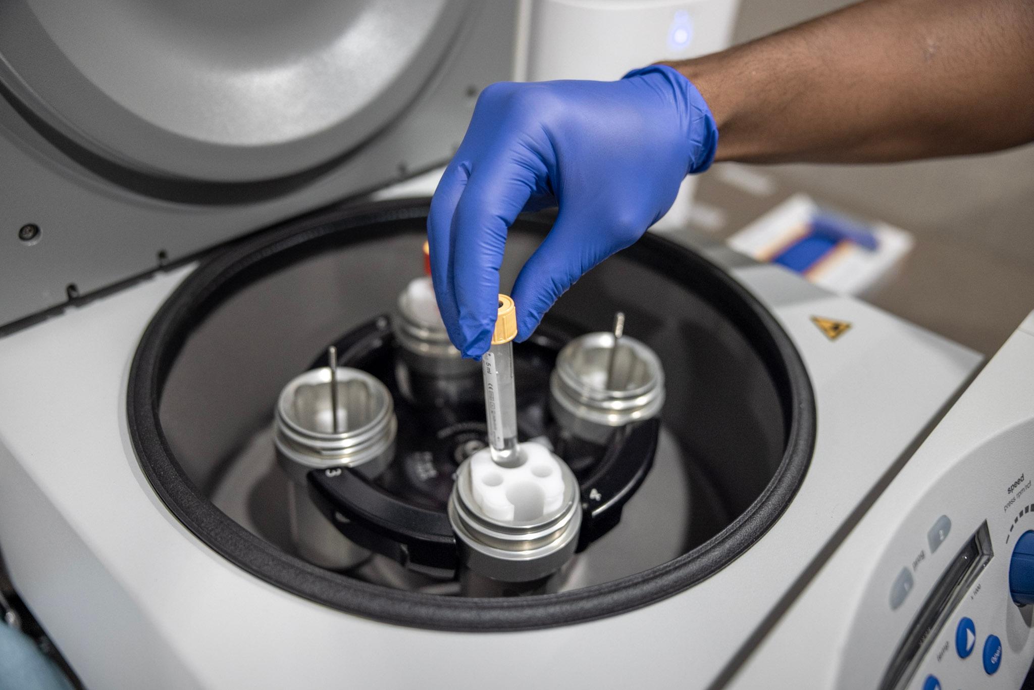 hand placing items in a centrifuge